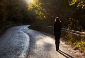 山道を一人トボトボ歩く若い女性