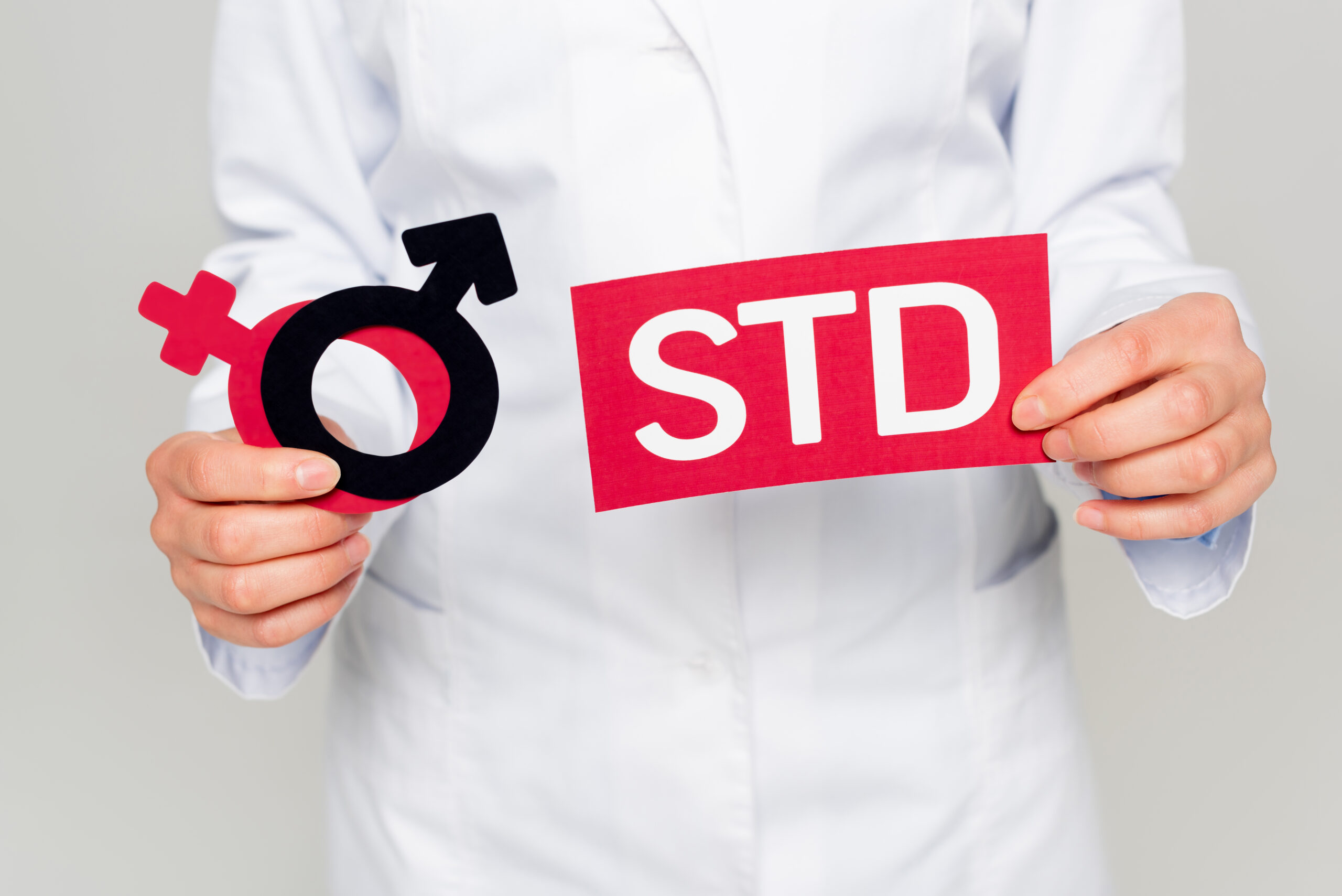 性感染症を表す「STD」の紙を持った男性