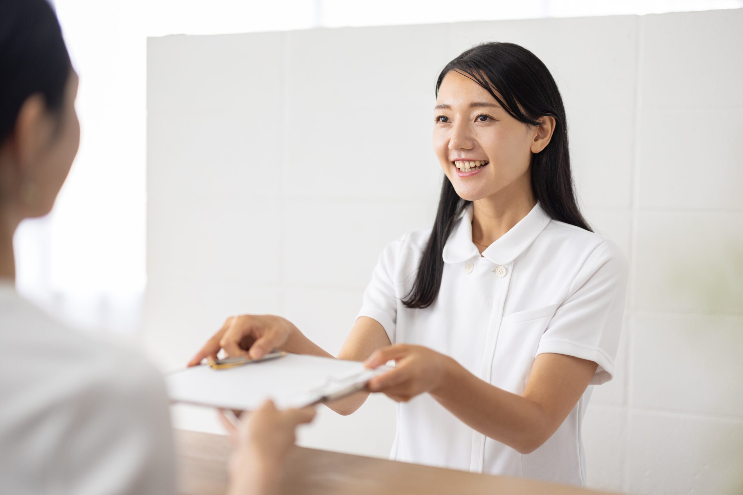 受付をする女性スタッフ